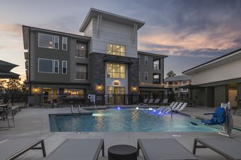 A large swimming pool in front of a modern apartment building.